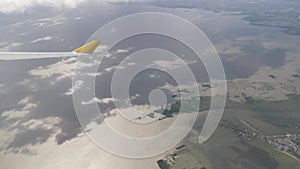 View from the airplane window showing skyline, clouds, beautiful forest, ocean, ships, mountains, islands, houses and buildings