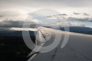 View from the airplane window with the sky and white clouds at the sunset. Flight above Ecuador Quito.