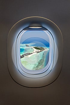 View from an airplane window to a tropical paradise island in the Maldives