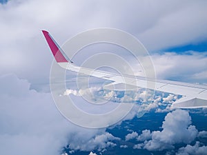 View from airplane window: wing plane in cloudy sky