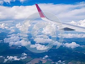 View from airplane window: wing plane in cloudy sky