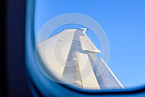 View on airplane wing against sky through the window