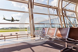 View from the airport lounge to landing aircraft, Car airfield maintenance at airport apron. Airplane travel concept