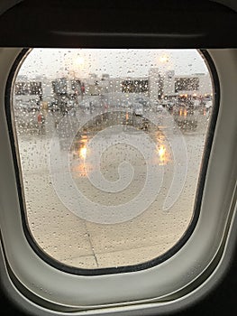 View of Airport terminal of an Airplane window on a rainy day