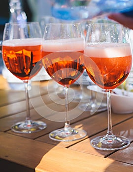 View of alcohol setting on catering banquet table, row line of orange red colored aperitif alcohol cocktails on a party, negroni,