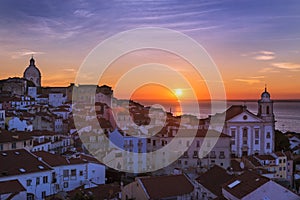 View of the Alfama neighbourhood from the Portas do Sol viewpoint at sunrise in Lisbon, Portuga