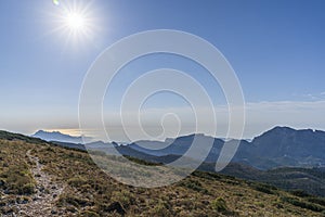 View of the Alicante coast from the top of the Aitana mountain with the sun in the left photo