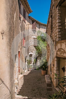 View of alley with stone houses and slope in Saint-Paul-de-Vence.