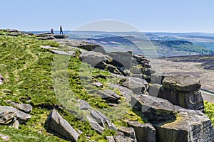 A view along the cliff top past millstone boulders on the Stanage Edge escarpment in the Peak District, UK