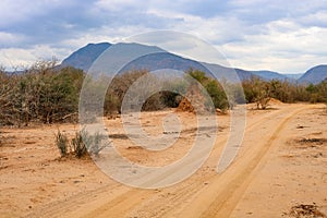 View along dusty road in zambezi valley with chirundu escarpment in background