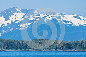 A view along the forested shoreline of the Gastineau Channel approaching Juneau, Alaska photo
