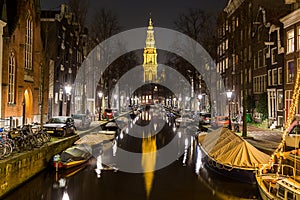 View along the Groenbuigwal canal towards the Zuiderkerk church at night.