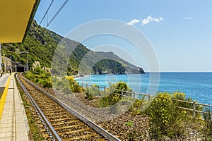 A view along the station platform and coastline at Corniglia, Italy