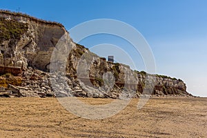 A view along the white, red and orange stratified chalk cliffs of Old Hunstanton, Norfolk, UK