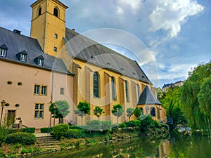 View of the Alzette river with St. John Church church of St. John or St. Jean du Grund at the background, in the Grund district