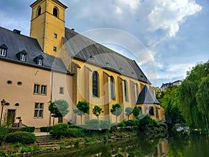 View of the Alzette river with St. John Church church of St. John or St. Jean du Grund at the background, in the Grund district