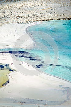 View of the amazing beach of Balos, with a family playing on the tropical sandy beach with turquoise waters