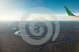 View of the Amazon River from an airplane, dense tropical forest, reflection in the water.