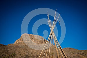 View of the american west with a saddle and a teepee
