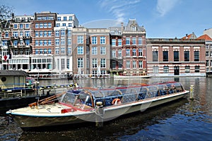 View of the Amsterdam canal with Dutch houses & tourist boat, Netherlands