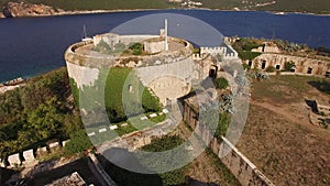 View of the ancient fortress Mamula, a yacht near it and the coast of the bay