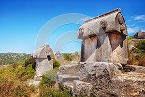 View of ancient Lycian sarcophagus tombs on a mountain near Kekova, lying on a Lycian way. Turkey.