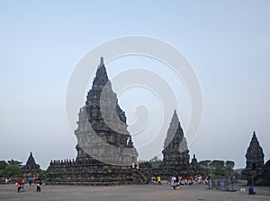 View of ancient Prambanan Temple Complex and tourist crowd at sunset in Yogyakarta