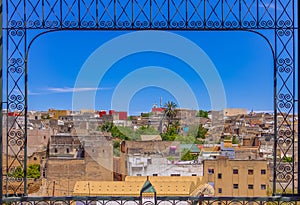 View of ancient rooftops of the Fez medina through an ornate met