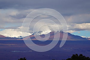 Andean volcanoes covered by clouds and snow, Atacama Desert, Chile