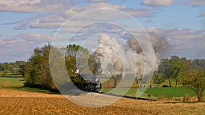 View of An Antique Steam Passenger Train Traveling Thru Trees and Farmlands