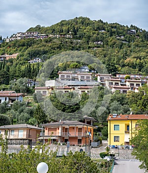 View on an apartment complex on a green hill above Terrazza del Brivido viewpoint. Garda Lake