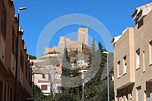 View of the Arab Castle of Almohad origin from the 12th century from a street in Biar, Alicante, Spain