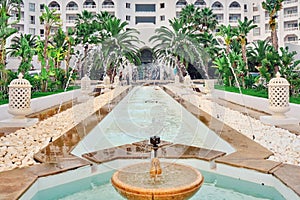 View of arabic hotel. Fountain in front of the hotel and the inscription Tunisia, Sousse