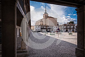 View of the arcaded square of Colmenar de Oreja with the Church of Santa Maria in the background, Spain photo