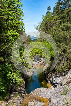 View into the Archbach gorge over a natural water basin in the forefront of the Stuiben waterfalls