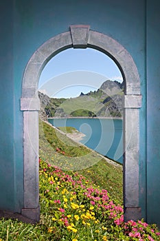 View through arched door; alpine lake and mountains