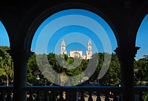 View through arches to the cathedral of Merida over the main square park `Plaza Grande` in Merida, Yucatan, Mexico photo