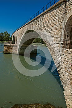 View of the arcs of the Pont d`Avignon bridge under a sunny blue sky, city of Avignon.