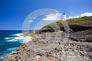 Arecibo lighthouse from Puerto Rico coast with rocky shore and ocean photo