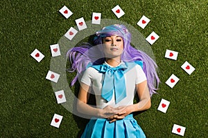 View of asian anime girl with cards lying on grass