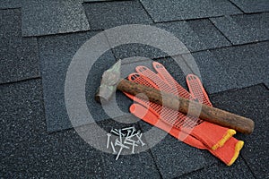 View on Asphalt Roofing Shingles Background. Roof Shingles - Roofing. Asphalt Roofing Shingles Hammer, Gloves and Nails