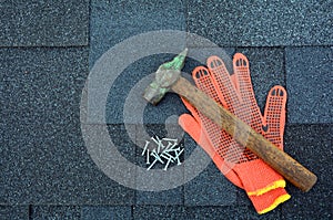 View on Asphalt Roofing Shingles Background. Roof Shingles - Roofing. Asphalt Roofing Shingles Hammer, Gloves and Nails