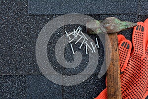 View on Asphalt Roofing Shingles Background. Roof Shingles - Roofing. Asphalt Roofing Shingles Hammer, Gloves and Nails
