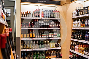 View of assorted liqueur bottles on store shelf.