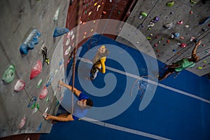 View of athletes examining climbing wall in health club