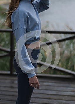 View on athletic body of a girl in blue gym suit outdoors