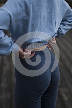 View of athletic body of a girl in blue gym suit outdoors