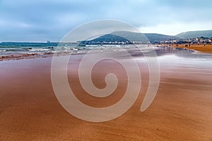 View of the Atlantic ocean coast in Agadir, Morocco. With Kasbah mountain on the background with inscription in Arabian: Allah,