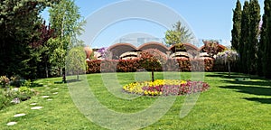 View of an attractive backyard with blooming flowers, conifers and well-kept lawns