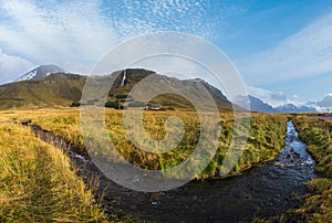 View during auto trip in South-West Iceland. Spectacular Icelandic landscape with scenic nature: mountains, fields, clouds,